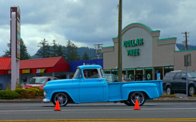 Colorful rhododendron festival parade float decorated with pink flowers moving through Florence Oregon coastal town